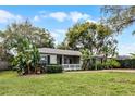 Well-maintained single-story home with a front yard featuring mature trees and landscaping at 1320 Golfview St, Orlando, FL 32804