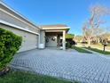 Paver driveway leads to an attached two-car garage with well-maintained landscaping at 13226 Zori Ln, Windermere, FL 34786