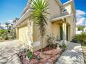 Side view of the house featuring a two-car garage, front entrance and manicured landscaping at 15323 Torpoint Rd, Winter Garden, FL 34787