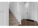 Bright entryway featuring carpeted stairs and wood flooring leading to a white front door at 1629 Hill Park Dr, Deltona, FL 32725