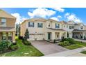 Aerial view showcasing a charming two-story home with a brick driveway, manicured lawn, and a welcoming front porch at 17846 Adrift Rd, Winter Garden, FL 34787