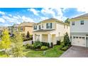 Aerial view showcasing a charming two-story home with lush landscaping, brick driveway and blue shutters at 17846 Adrift Rd, Winter Garden, FL 34787