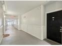 Well-lit hallway with neutral colors and classic paneling leading to unit door at 202 E South St # 5037, Orlando, FL 32801