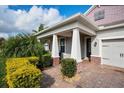 Inviting front porch with brick accents, decorative columns, and well-maintained landscaping at 2157 Bay Line Rd, Oakland, FL 34787