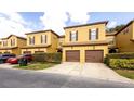 Close exterior of townhouses with attached garages and beautifully maintained landscaping at 2344 Aloha Bay Ct, Ocoee, FL 34761