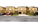 Exterior view of townhouses with garages and neutral colored facade and well maintained landscaping at 2344 Aloha Bay Ct, Ocoee, FL 34761