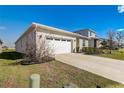 Showing the home's ample driveway and a manicured lawn, under a bright blue sky at 362 Sofia Ln, Lake Alfred, FL 33850