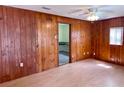 This bedroom has wooden walls, vinyl flooring, and a ceiling fan at 435 Pleasant St, Lake Helen, FL 32744