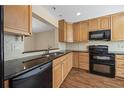 Functional kitchen with wooden cabinetry, black appliances, and sleek countertops at 483 Green Spring Cir, Winter Springs, FL 32708