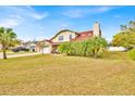 Attractive two-story home with a red roof, a brick front, and lush landscaping in a bright, sunny setting at 5108 Avignon Ct, Orlando, FL 32839