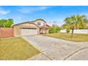 Exterior view of a two story home with brick accents, spacious driveway and well maintained lawn at 5108 Avignon Ct, Orlando, FL 32839