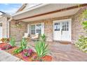 Inviting front porch with seating area, landscaped flower beds, and double door entry at 5108 Avignon Ct, Orlando, FL 32839