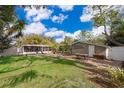 Expansive backyard featuring a screened-in porch, outdoor seating, and mature landscaping at 5214 E Kaley St, Orlando, FL 32812