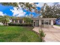 Charming home with a lush green lawn, decorative shrubbery, and inviting entrance at 5214 E Kaley St, Orlando, FL 32812