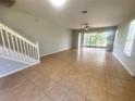 Bright living room with tile flooring, stairs, and a sliding glass door to the outside at 6292 Twain Street # 108, Orlando, FL 32835