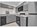 Well-lit kitchen with gray cabinets, modern appliances, and ample counter space at 705 Northlake Dr # 705, Sanford, FL 32773