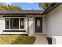 Inviting front entry with decorative door, adjacent window, and clean landscaping at 7427 Houston E Ct, Winter Park, FL 32792