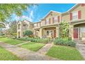 Townhouse with brick walkway, covered porch seating, manicured lawn, and beautiful landscaping at 9130 Sabal Pine Way, Orlando, FL 32832