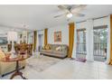 Bright living room with tile flooring, modern ceiling fan, and view of the balcony at 120 Hibiscus Woods Ct # 13B, Deltona, FL 32725