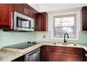 Modern kitchen featuring stainless steel appliances, granite countertops, and stylish dark wood cabinetry at 127 Georgetown Dr # 127, Casselberry, FL 32707