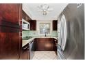 Well-lit kitchen with stainless steel appliances, granite countertops, and attractive tile backsplash and flooring at 127 Georgetown Dr # 127, Casselberry, FL 32707