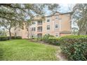 Exterior view of a multi-story condo building with well-manicured landscaping and a bright sky at 13500 Turtle Marsh Loop # 839, Orlando, FL 32837