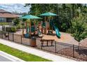 Community playground featuring slides, climbing structures, and seating for families to enjoy at 1377 Sawgrass Hammock Ln, Davenport, FL 33837