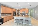 Spacious kitchen featuring an island with pendant lighting, ample wooden cabinetry, stainless steel appliances, and tile flooring at 1440 Pro Shop Ct, Davenport, FL 33896