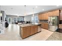 Open-concept kitchen with island, stainless steel appliances, seamlessly connected to a living area with large windows and neutral tones at 1440 Pro Shop Ct, Davenport, FL 33896