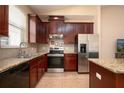 Well-equipped kitchen featuring granite countertops, stainless steel appliances, and dark wood cabinets at 15341 Urbino Ln, Orlando, FL 32828