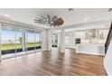 Open-concept living room boasts wood flooring, a statement fan, and sliding glass doors with outdoor views at 1595 Juniper Hammock St, Winter Garden, FL 34787