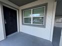 Close up of the front entry with a black door and an adjacent window at 220 Palm Ave, Auburndale, FL 33823