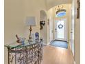 Inviting entryway with hardwood floors, glass console table, and arched doorway at 221 Chippendale Ter, Oviedo, FL 32765