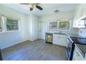 Bright kitchen with a sunflower adorned dishwasher, complemented by white cabinetry and wood look floors at 2401 S Myrtle Ave, Sanford, FL 32771