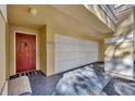 Welcoming entryway of a townhouse with a red front door and attached garage, showcasing curb appeal at 2425 Legacy Lake Dr # 2425, Maitland, FL 32751