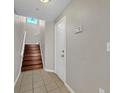 Bright townhouse entryway with staircase, light-colored walls, and tiled flooring, leading to the upper levels at 2425 Legacy Lake Dr # 2425, Maitland, FL 32751