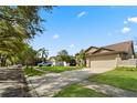 Suburban house with a manicured lawn, a two-car garage, and a driveway, under a clear blue sky at 338 Silver Pine Dr, Lake Mary, FL 32746