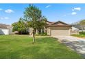 Beautifully landscaped front yard with lush green grass and a well-maintained exterior featuring a convenient two-car garage at 338 Silver Pine Dr, Lake Mary, FL 32746