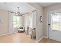 Inviting living room with ample natural light, stylish light fixture, and a modern door at 3438 Orange Rose Loop, Apopka, FL 32712