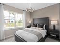 Comfortable bedroom featuring a large window, modern lighting fixture, and stylish decor at 3438 Orange Rose Loop, Apopka, FL 32712