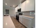 Well-equipped kitchen featuring stainless steel appliances, white cabinets, and granite countertops at 3660 Pandora Dr, Indian Lake Estates, FL 33855