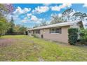 Well-kept single-story home with a metal roof and a spacious, green yard at 4898 Meadow Dr, St Cloud, FL 34772