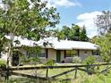 Charming single-story home featuring a well-maintained lawn, mature trees, and a quaint, fenced front yard at 4898 Meadow Dr, St Cloud, FL 34772