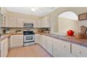 Functional kitchen with white cabinets, tile countertops, and stainless steel appliances at 4898 Meadow Dr, St Cloud, FL 34772