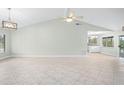 Bright living room with tile floors, vaulted ceiling, and adjacent kitchen at 517 Seville Ave, Altamonte Springs, FL 32714