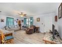 Comfortable living room features neutral walls, updated flooring, a ceiling fan and abundant natural light at 59 Aberdeen Cir, Leesburg, FL 34788