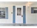 Inviting front door with blue shutters and a modern digital lock at 7 Great Oak Dr, Fruitland Park, FL 34731