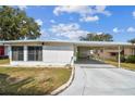 Single story home with covered parking and a well-maintained lawn under a sunny sky at 7 Great Oak Dr, Fruitland Park, FL 34731