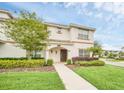 Inviting two-story home featuring lush landscaping and a welcoming front entrance at 9017 Dogleg Dr, Davenport, FL 33896