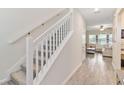 Carpeted staircase with white railing leading to the upper level and a view of the living room at 1100 Downswing Pl, Davenport, FL 33896